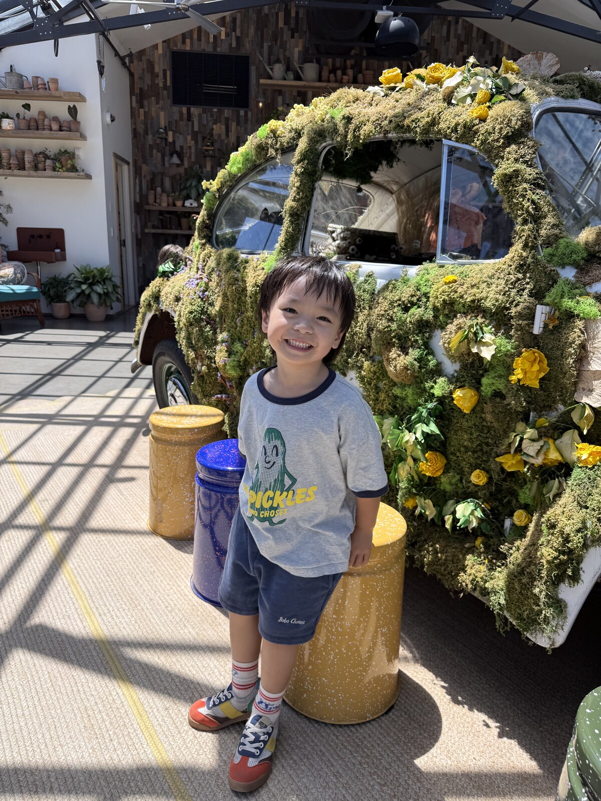 Jichang smiling beside a flower-covered vintage car