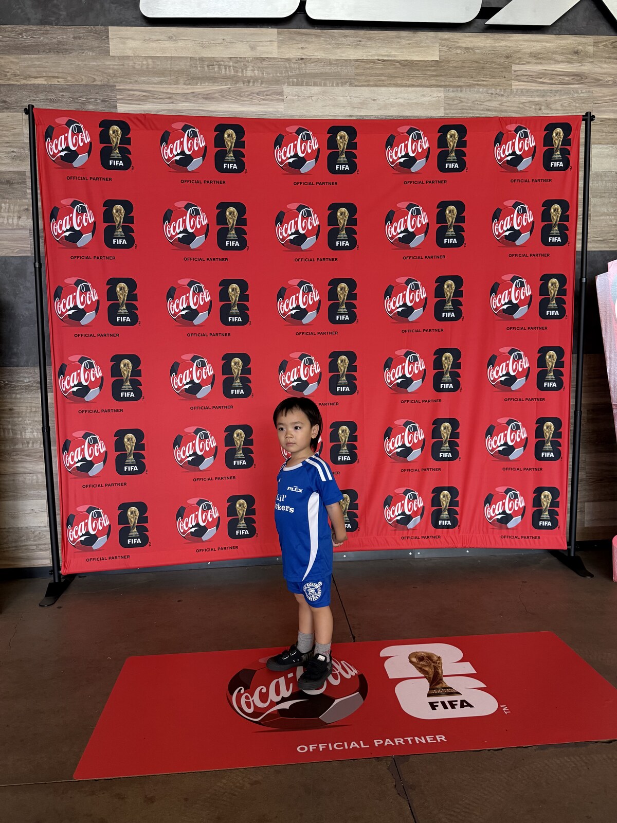 Jichang standing in front of a FIFA World Cup soccer backdrop