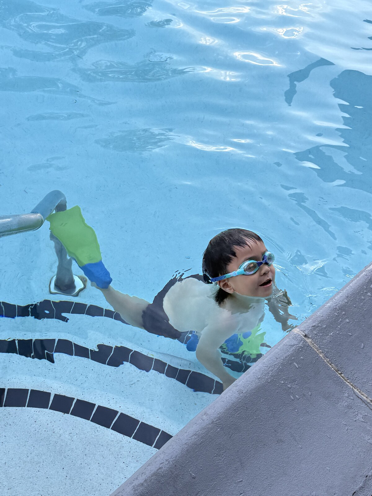 Jichang wearing goggles and kicking in the pool after dinner