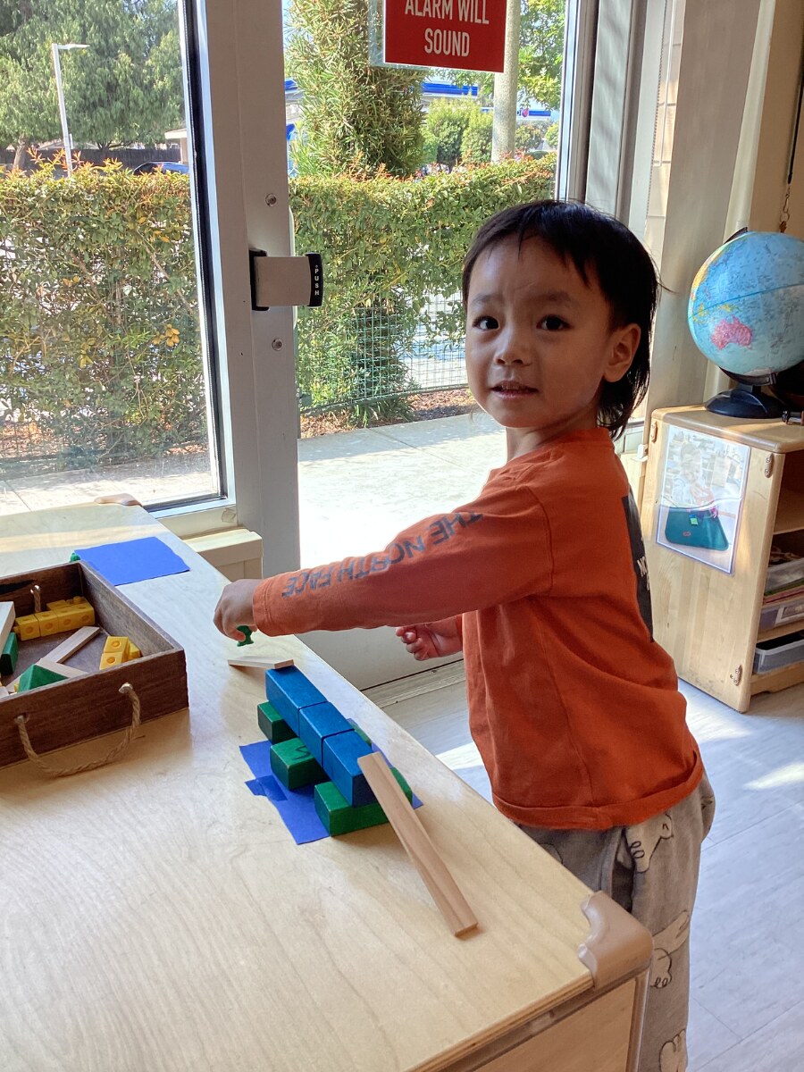 Jichang building a bridge with blocks during a classroom bridge challenge