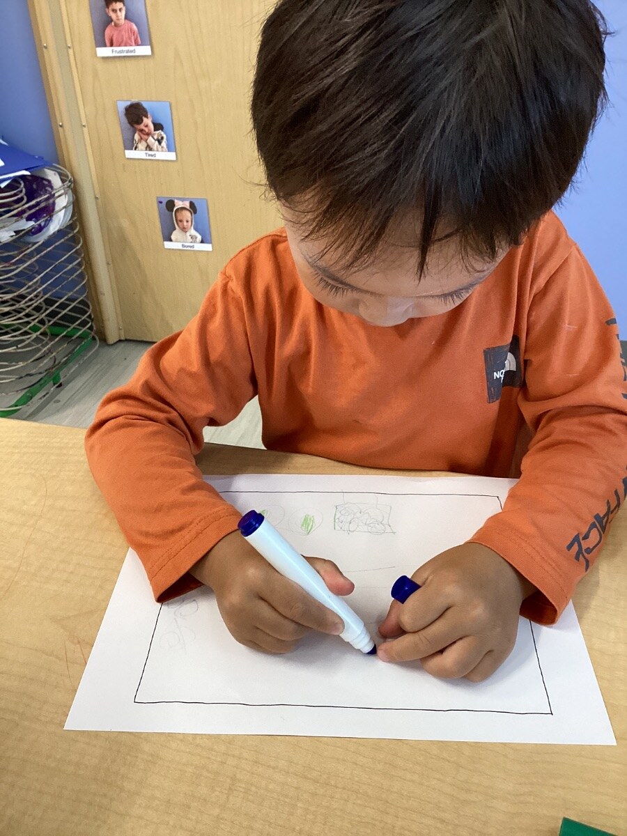 Jichang drawing a map of the outside playground at school