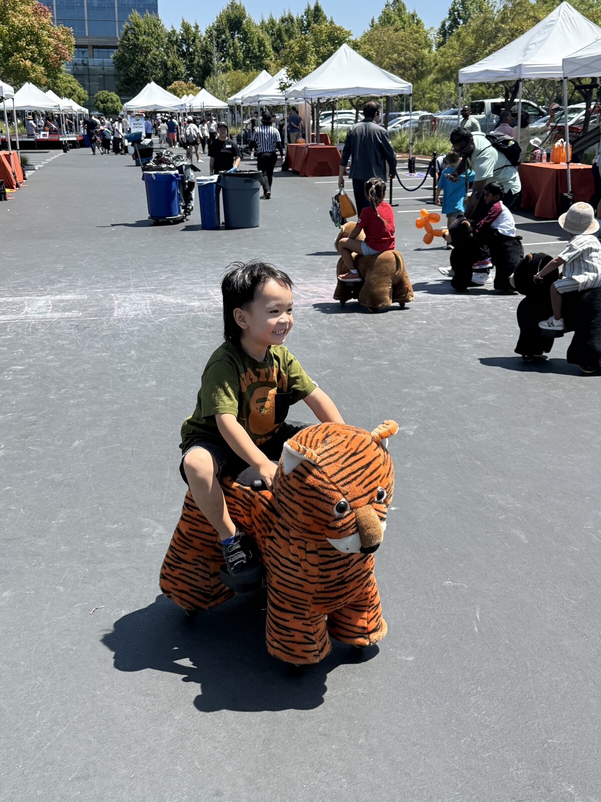 Jichang riding a small tiger motorcycle at the kids event