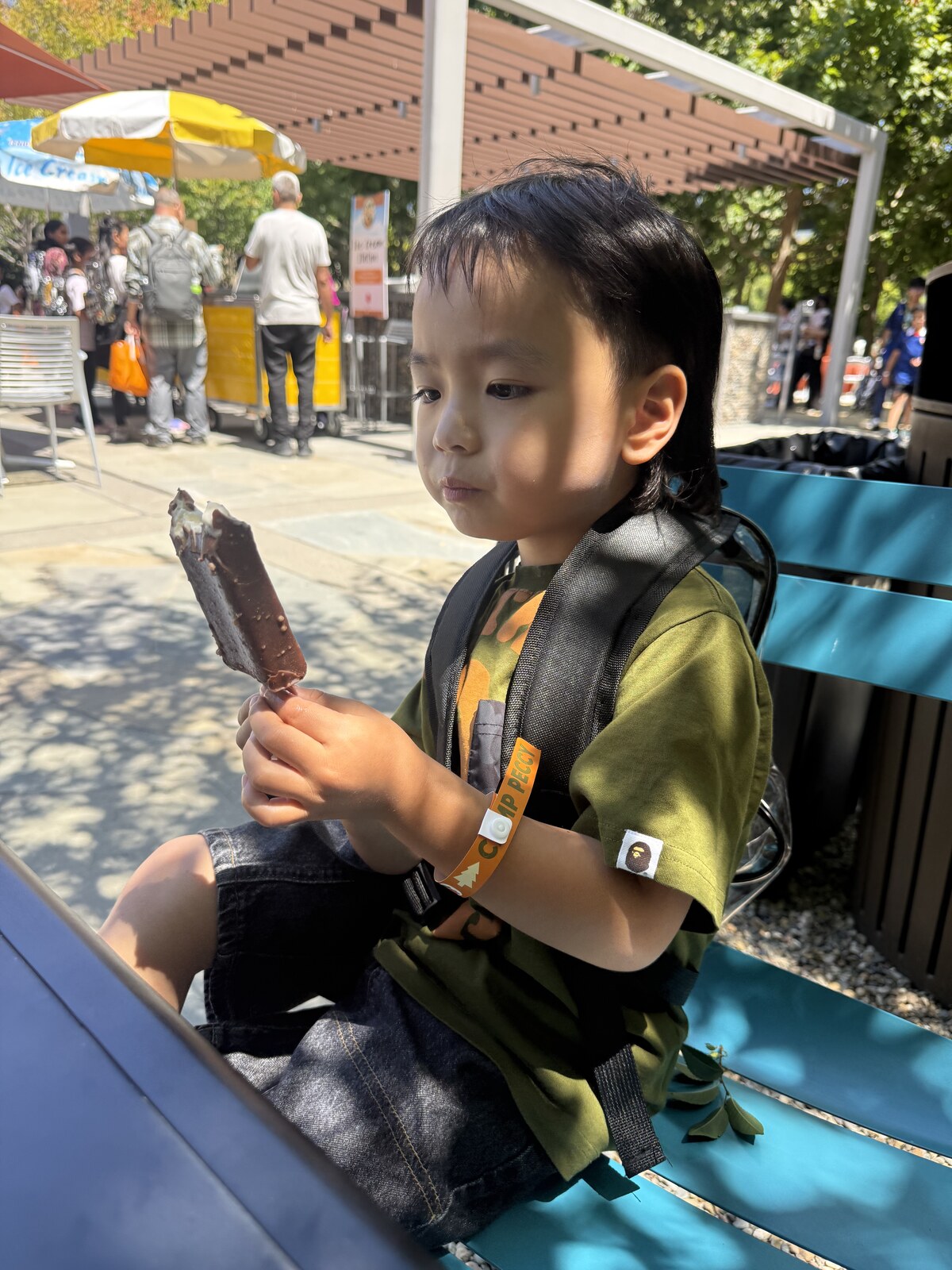 Jichang eating a crunchy chocolate vanilla ice cream bar outside
