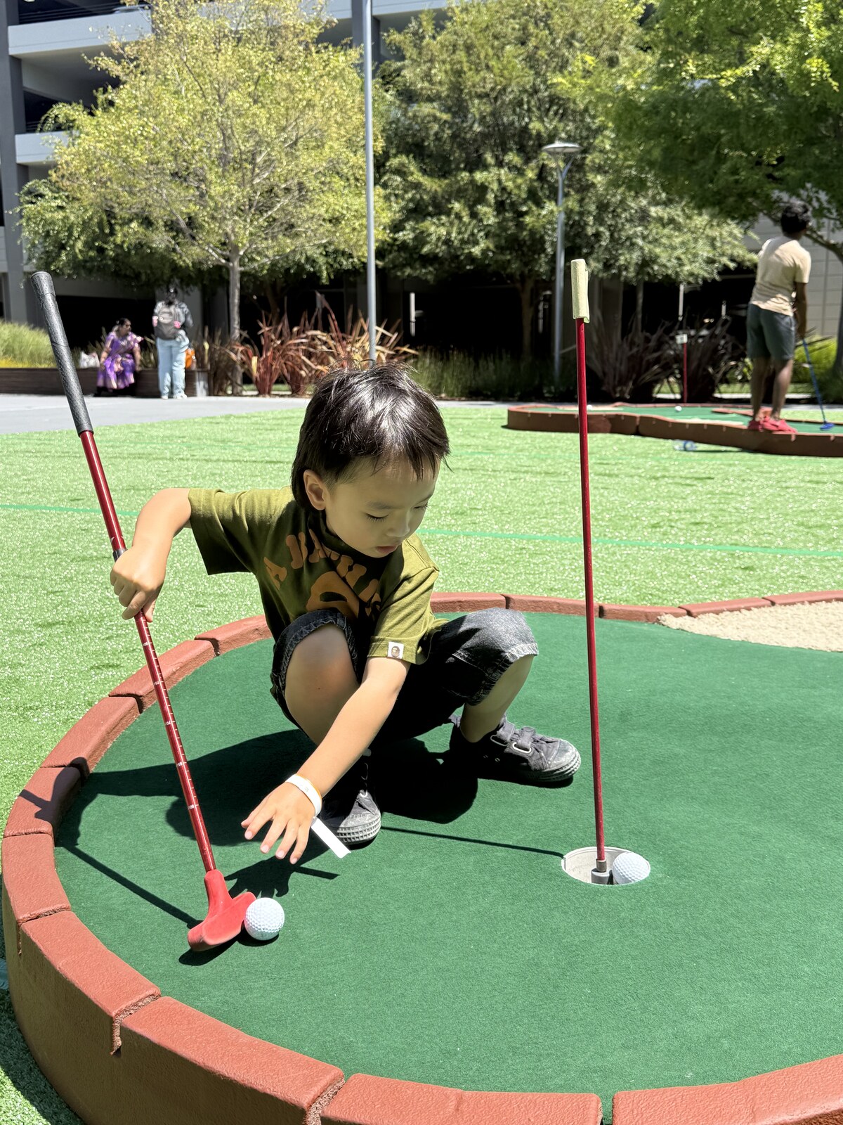 Jichang lining up a putt on a mini golf course