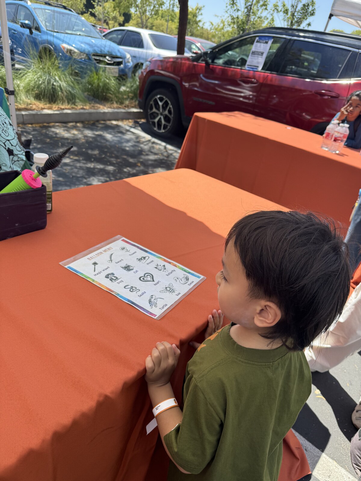 Jichang looking at balloon animal choices at a table