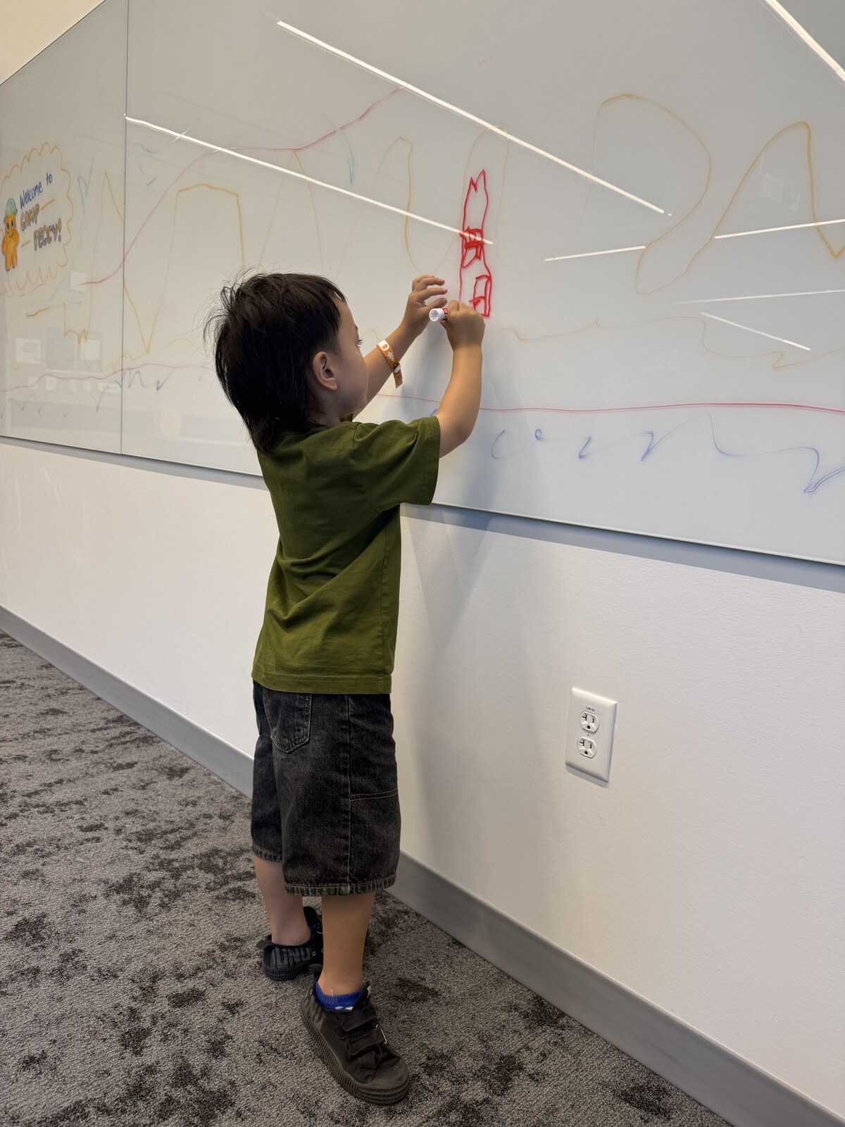Jichang carefully drawing a castle on a large whiteboard