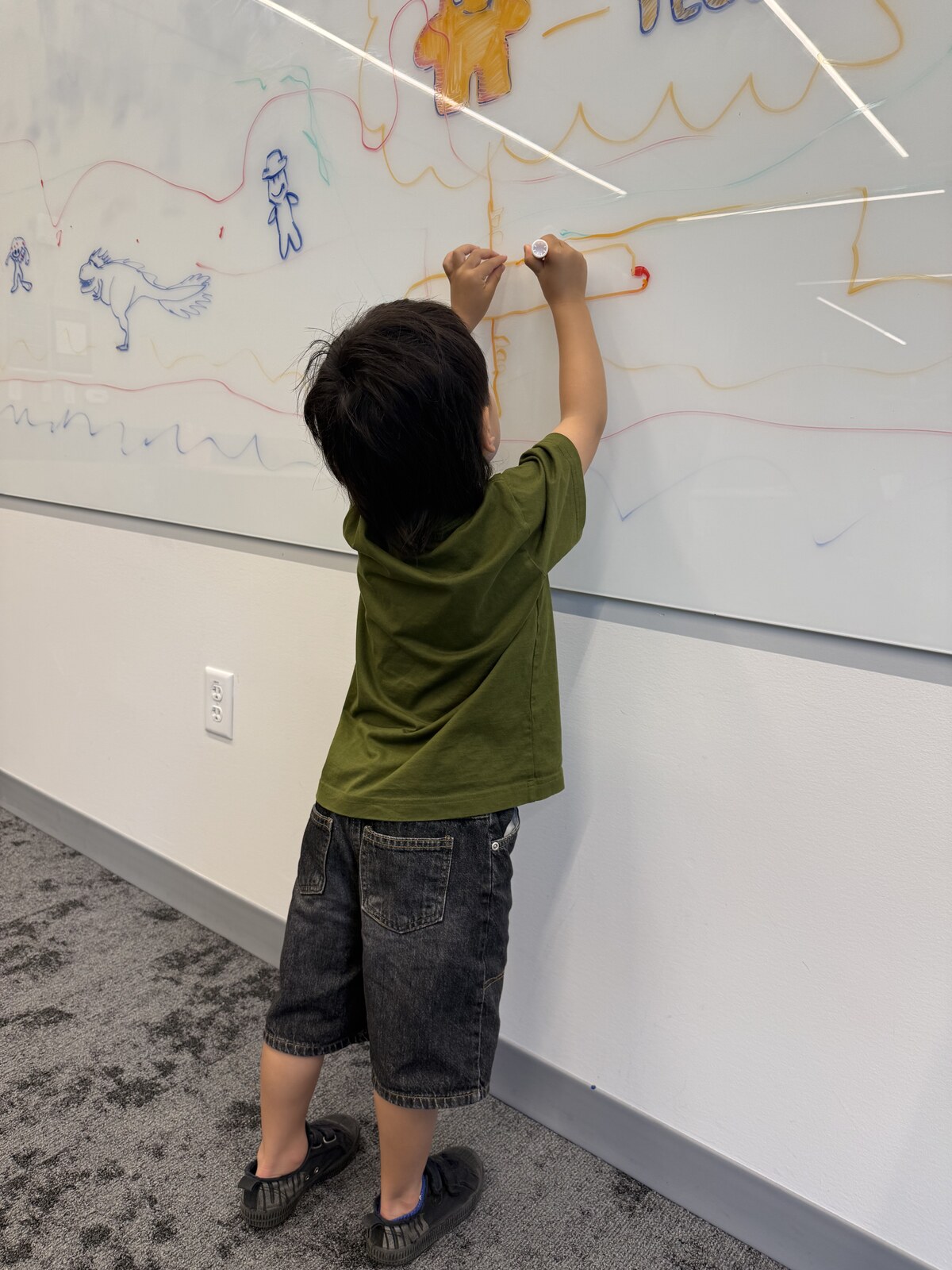 Jichang drawing an airplane on a large whiteboard