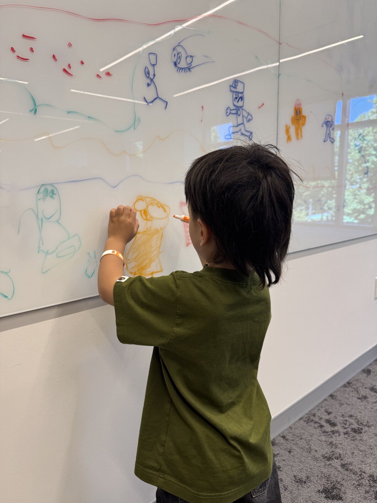 Jichang drawing an astronaut on a large whiteboard
