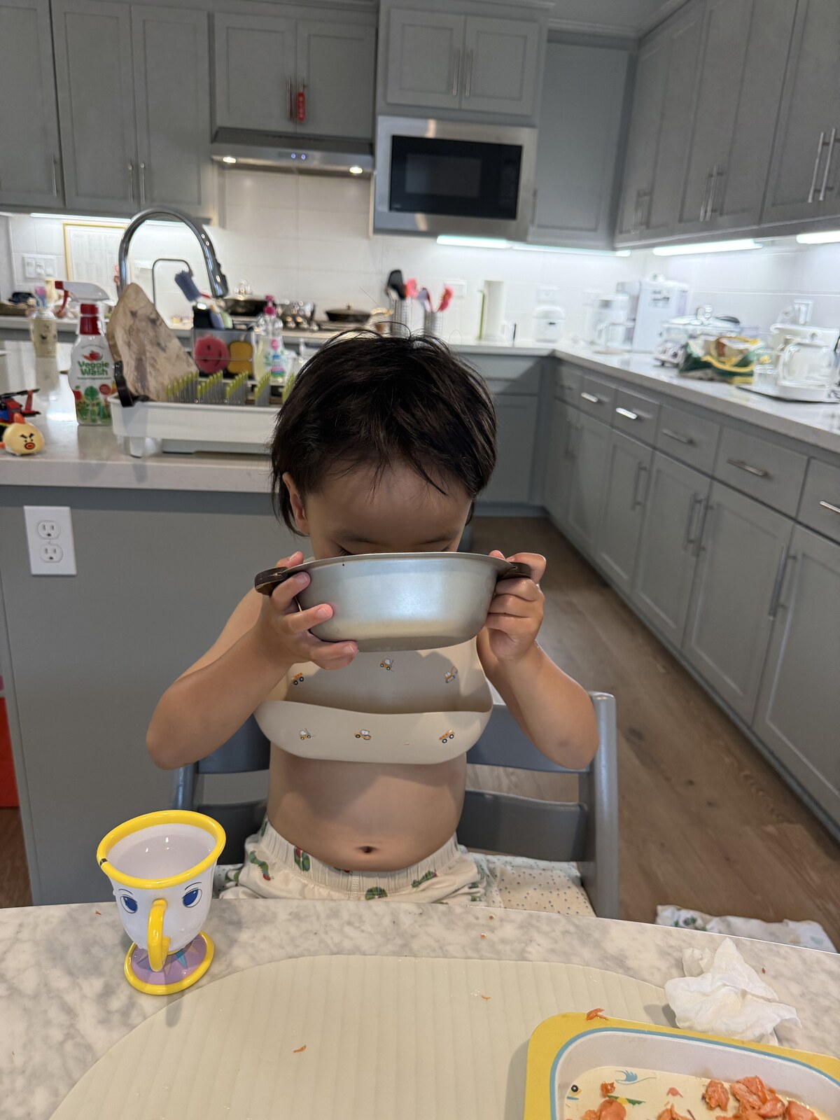 Jichang holding a bowl with both hands and drinking soup at dinner