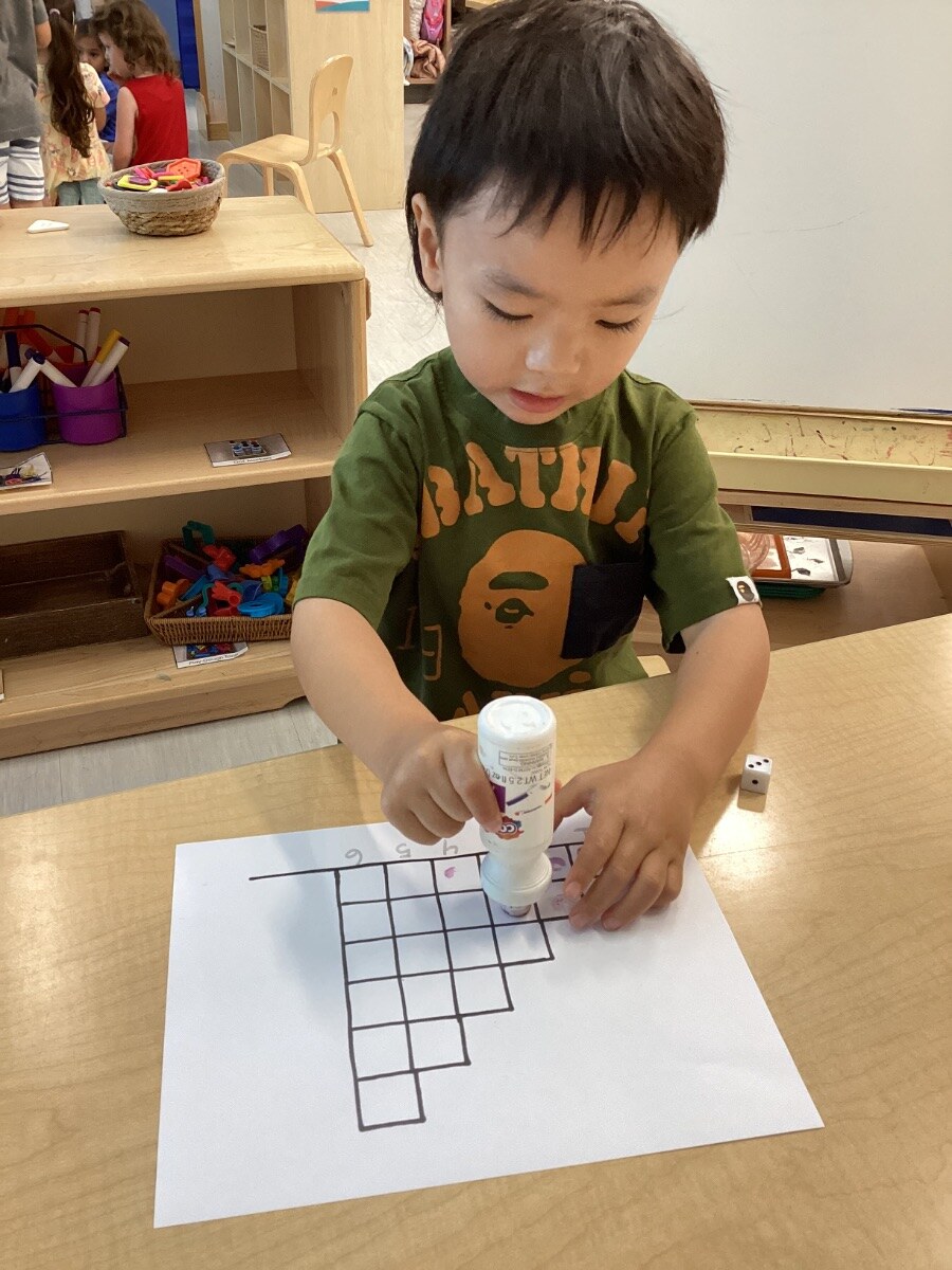 Jichang using a dot marker during a dice and number matching game