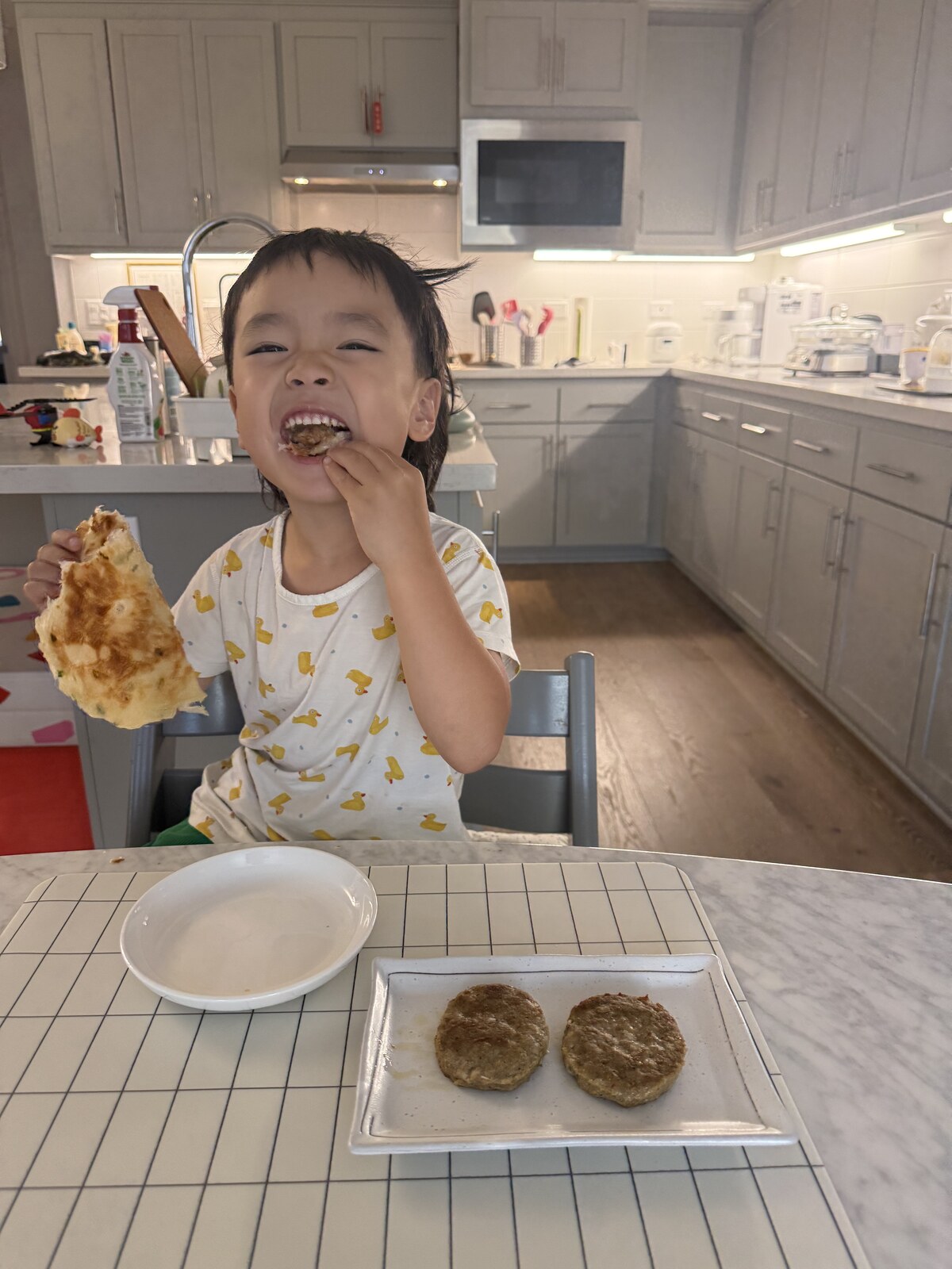 Jichang eating pancakes and sausage patties at breakfast