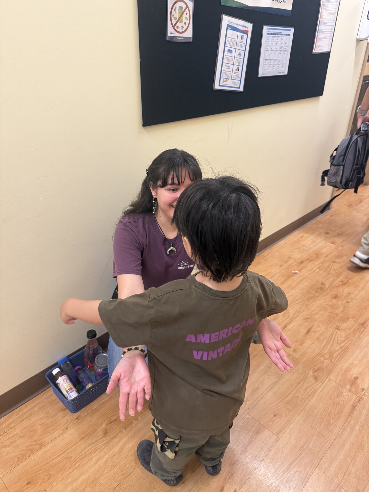 Jichang greeting Miss Esme in the Bright Horizons hallway
