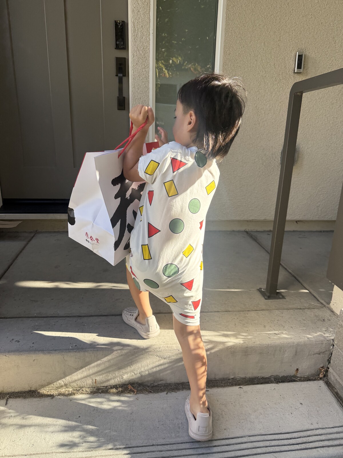 Jichang carrying a Din Tai Fung delivery bag outside