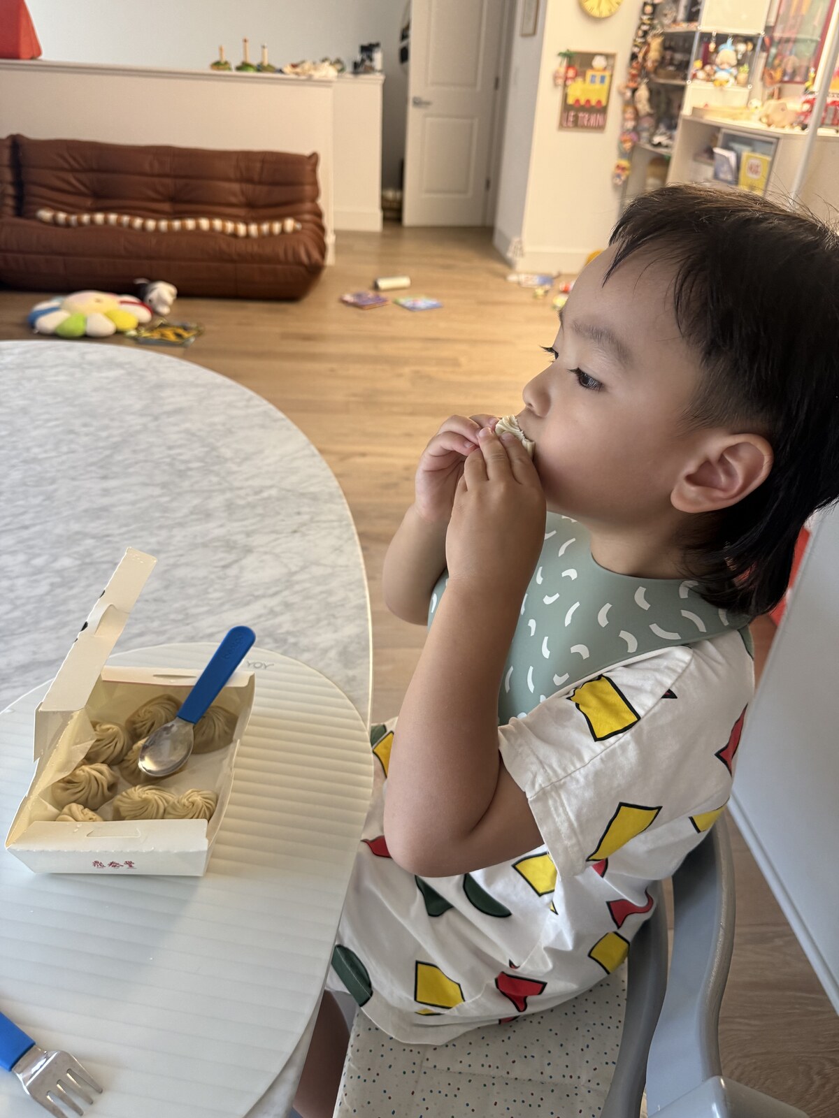 Jichang drinking soup from a xiao long bao before eating it