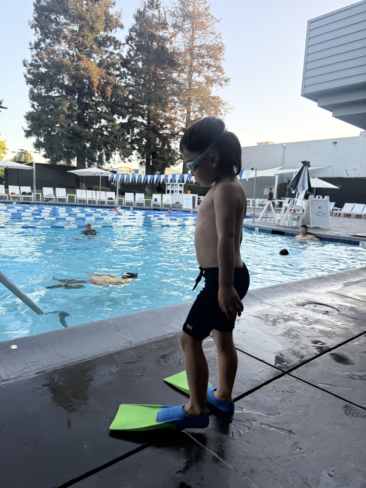 Jichang wearing a TYR jammer and goggles beside the swimming pool