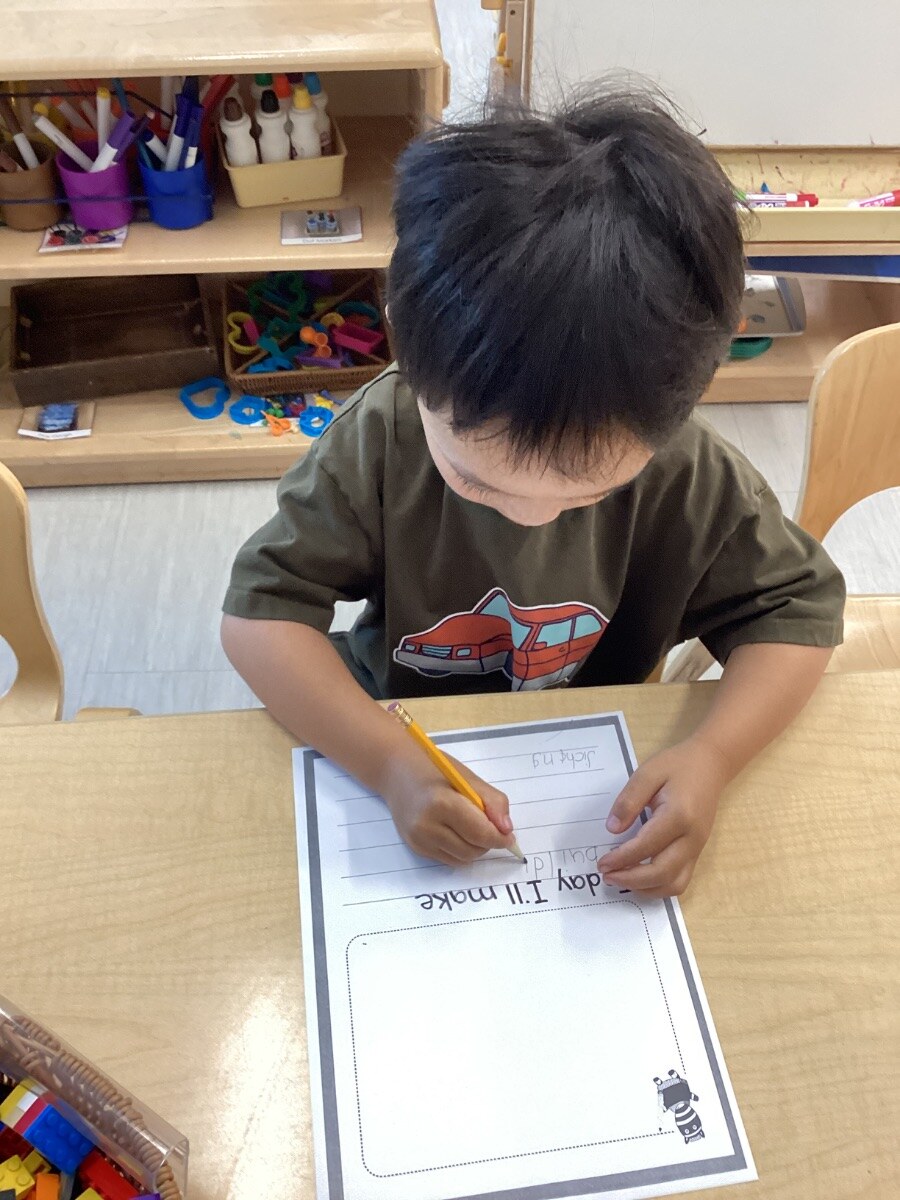 Jichang writing an answer at a Bright Horizons table