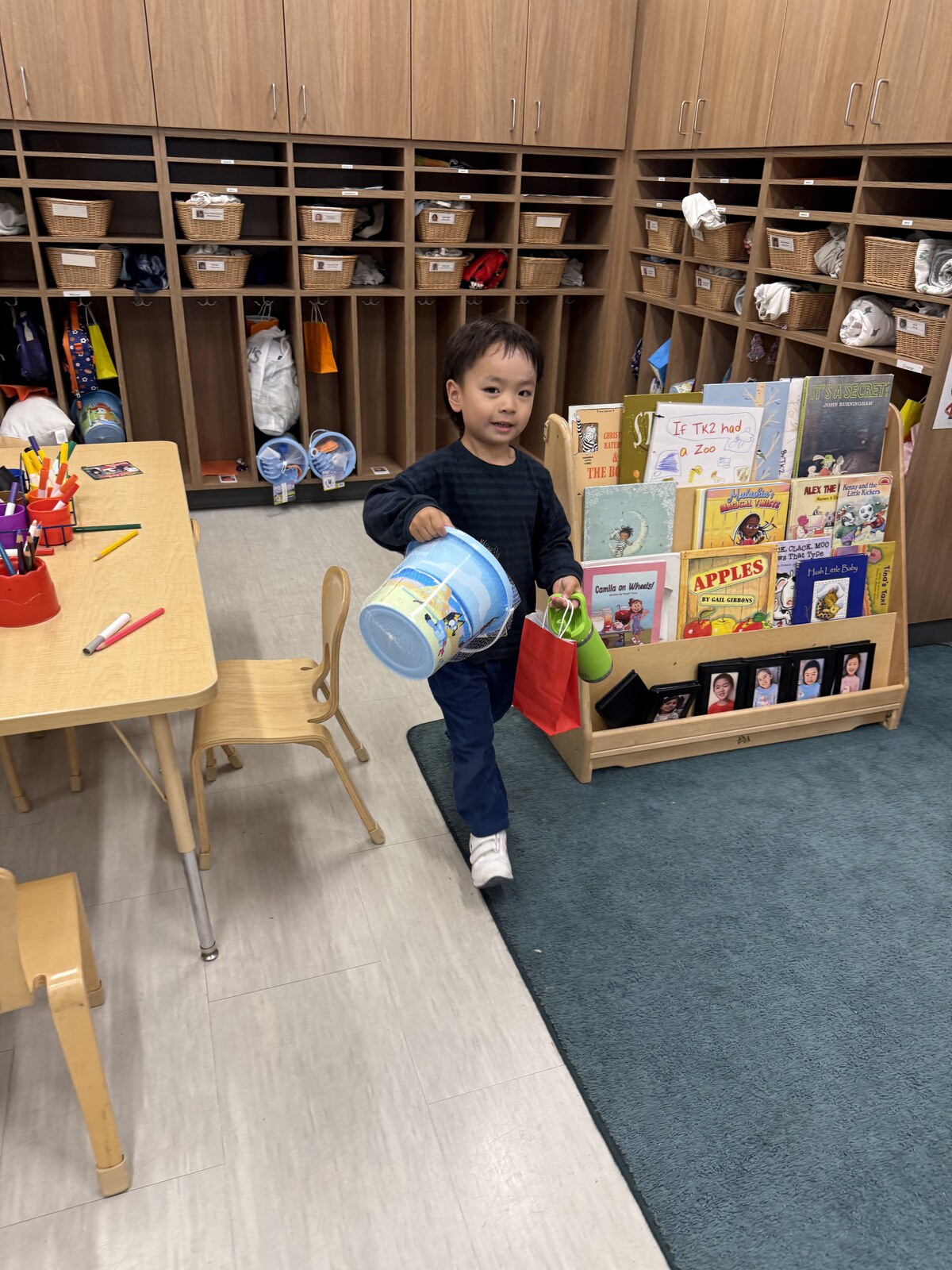 Jichang standing near cubbies with goodie bags and a Bluey bucket