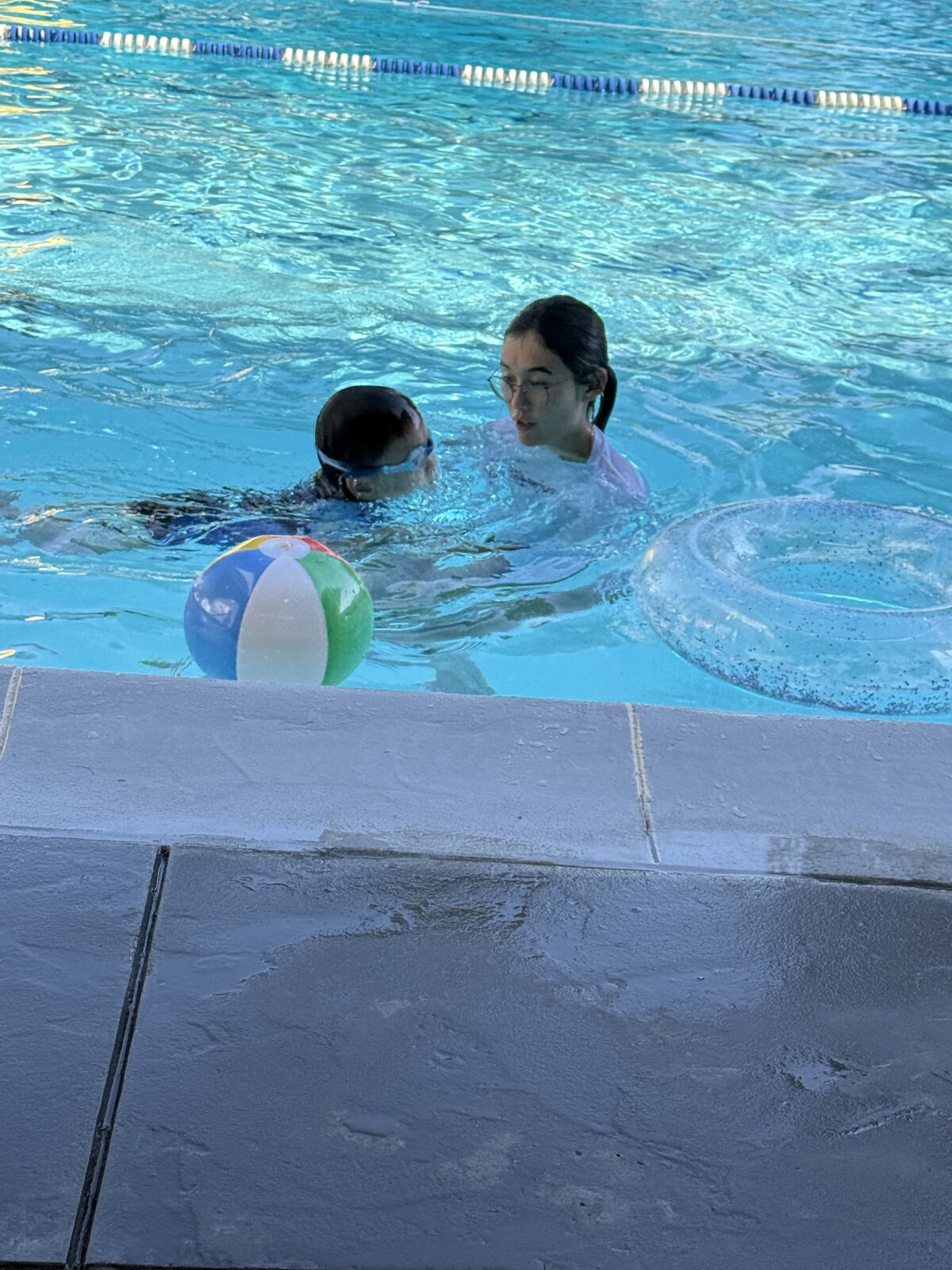 Jichang practicing freestyle with Coach Lana during swim lesson
