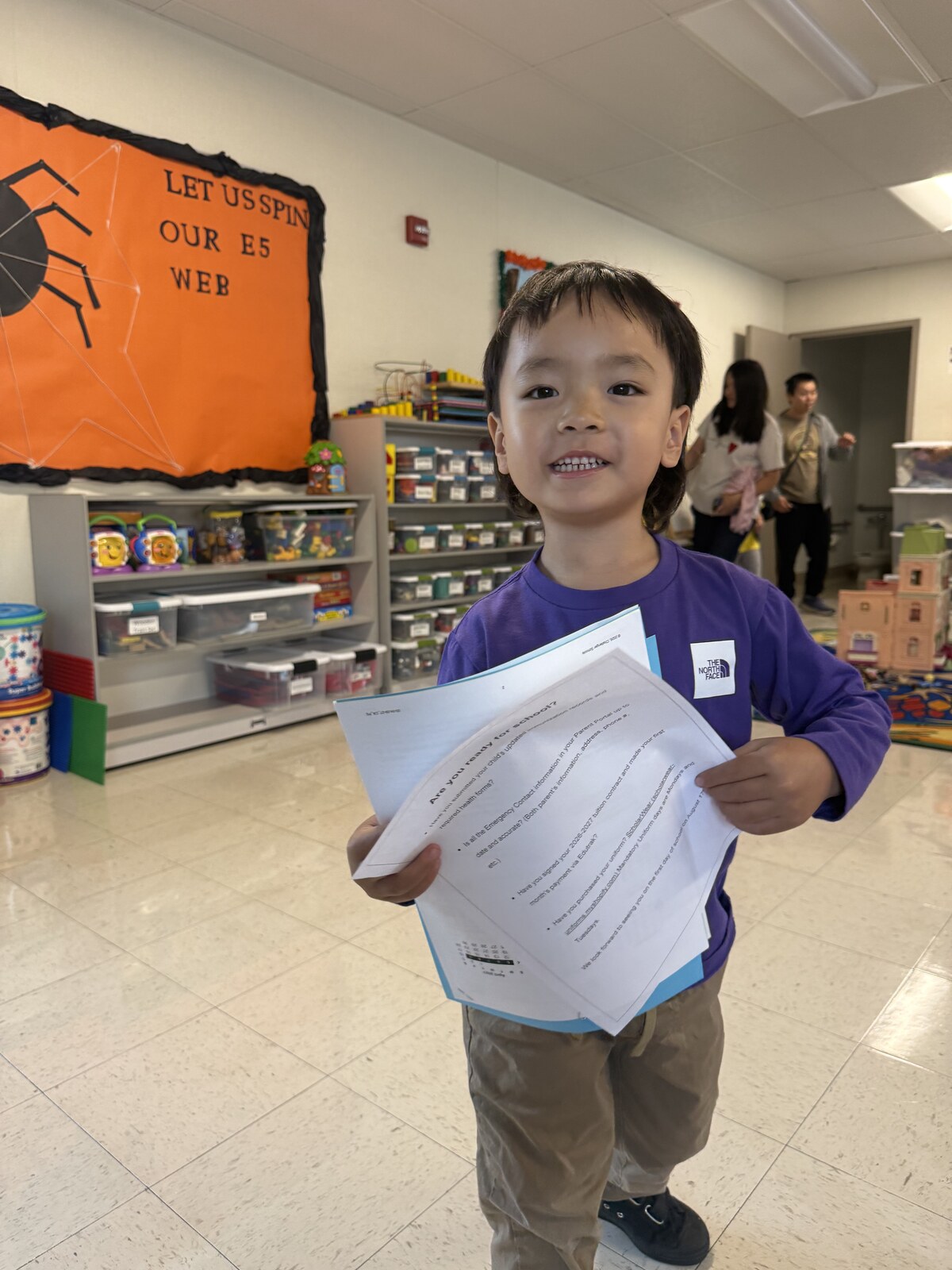 Jichang holding classroom papers inside his roomy new Challenger School classroom