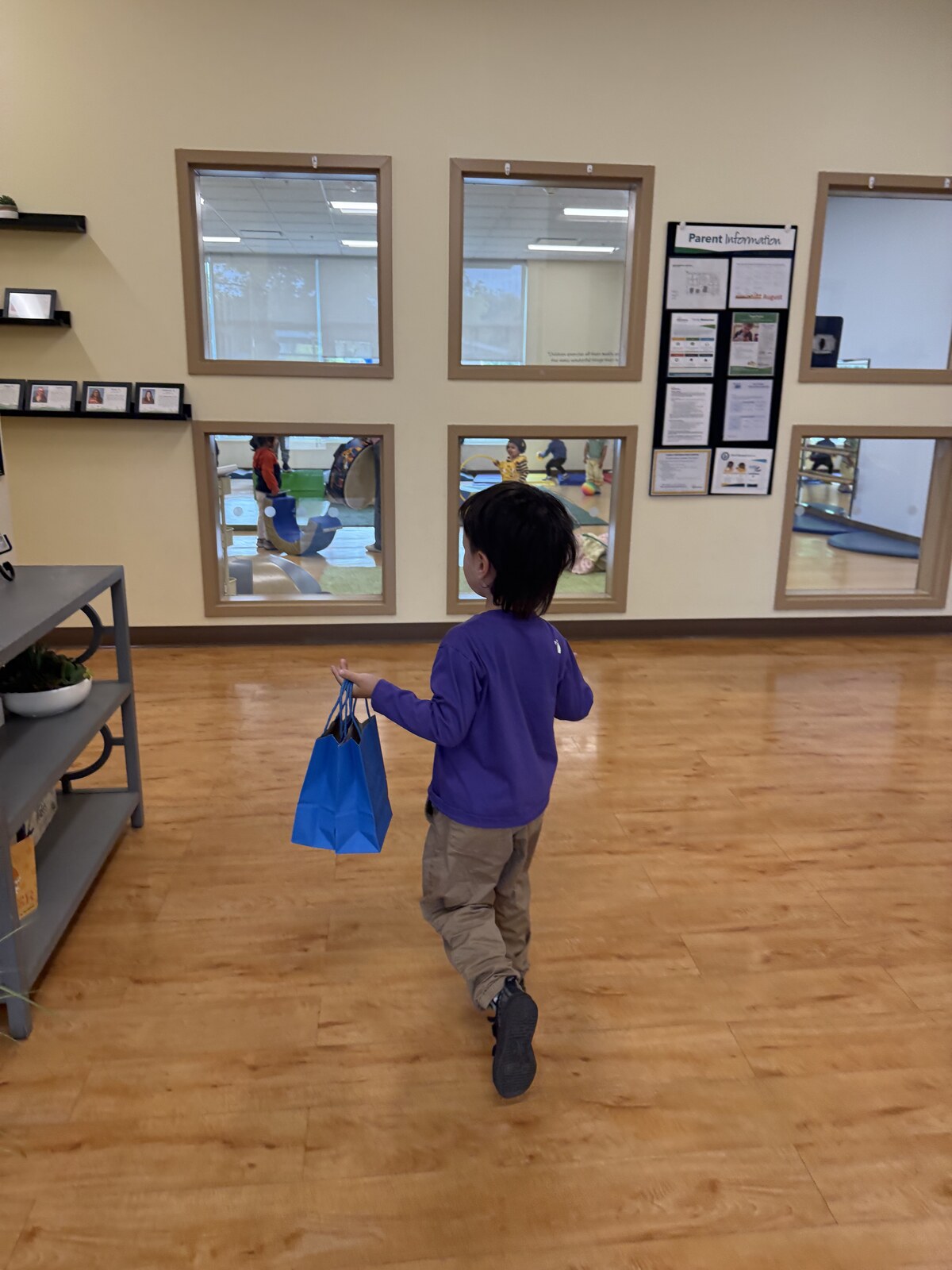 Jichang carrying two blue goodie bags into Bright Horizons for classmates