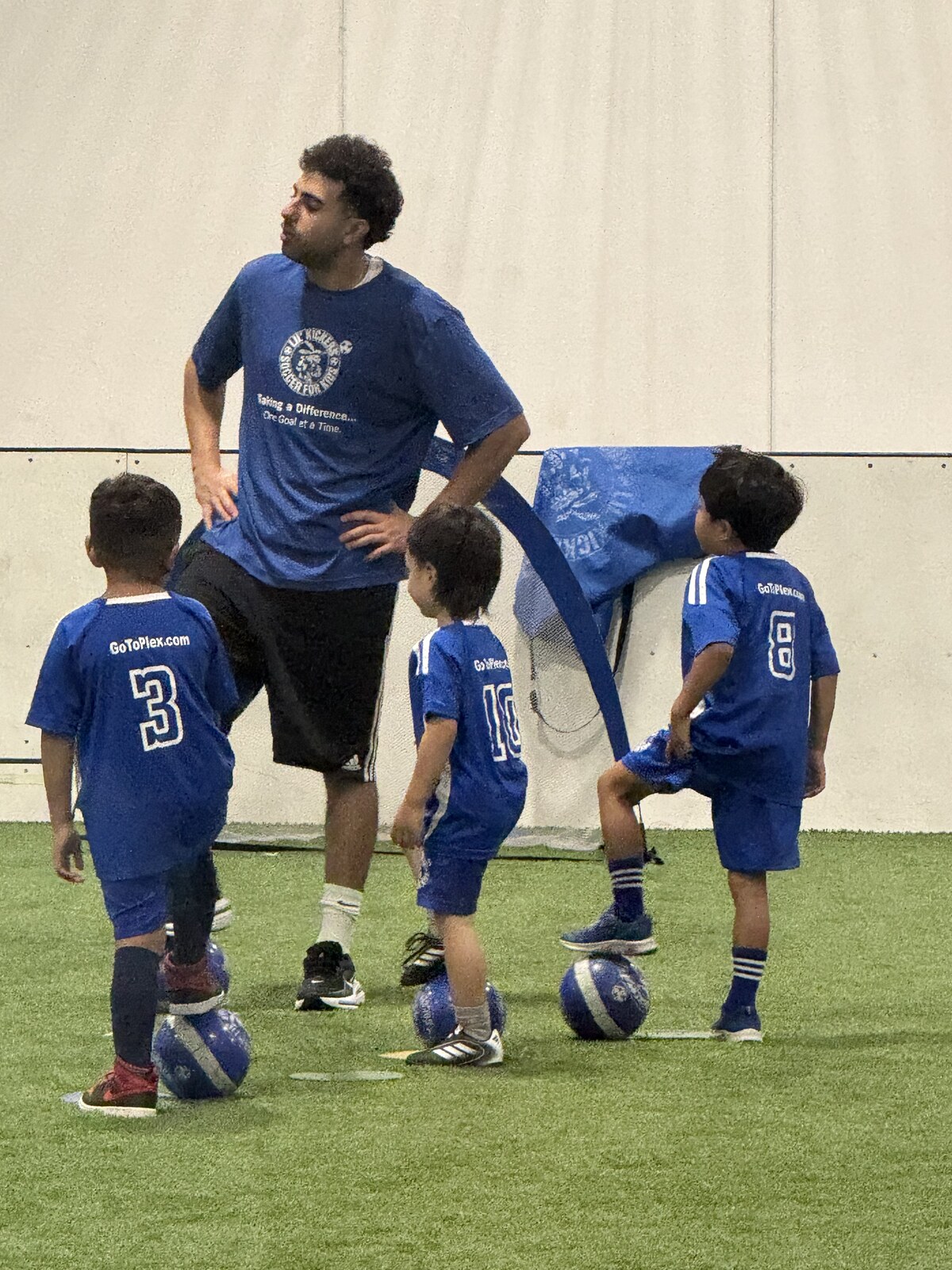 Jichang warming up at soccer class by rolling a ball with his foot