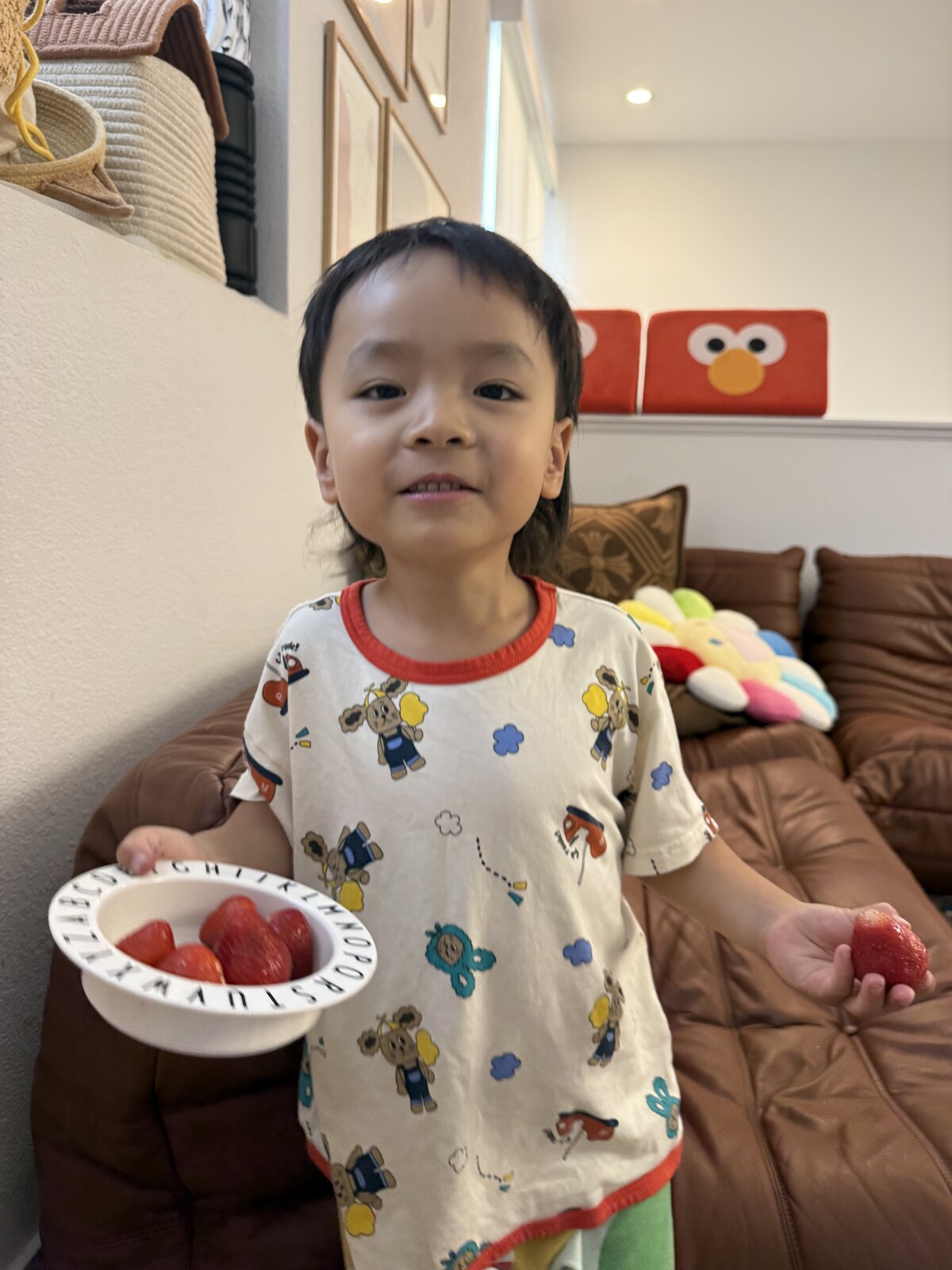 Jichang holding a plate of strawberries at home