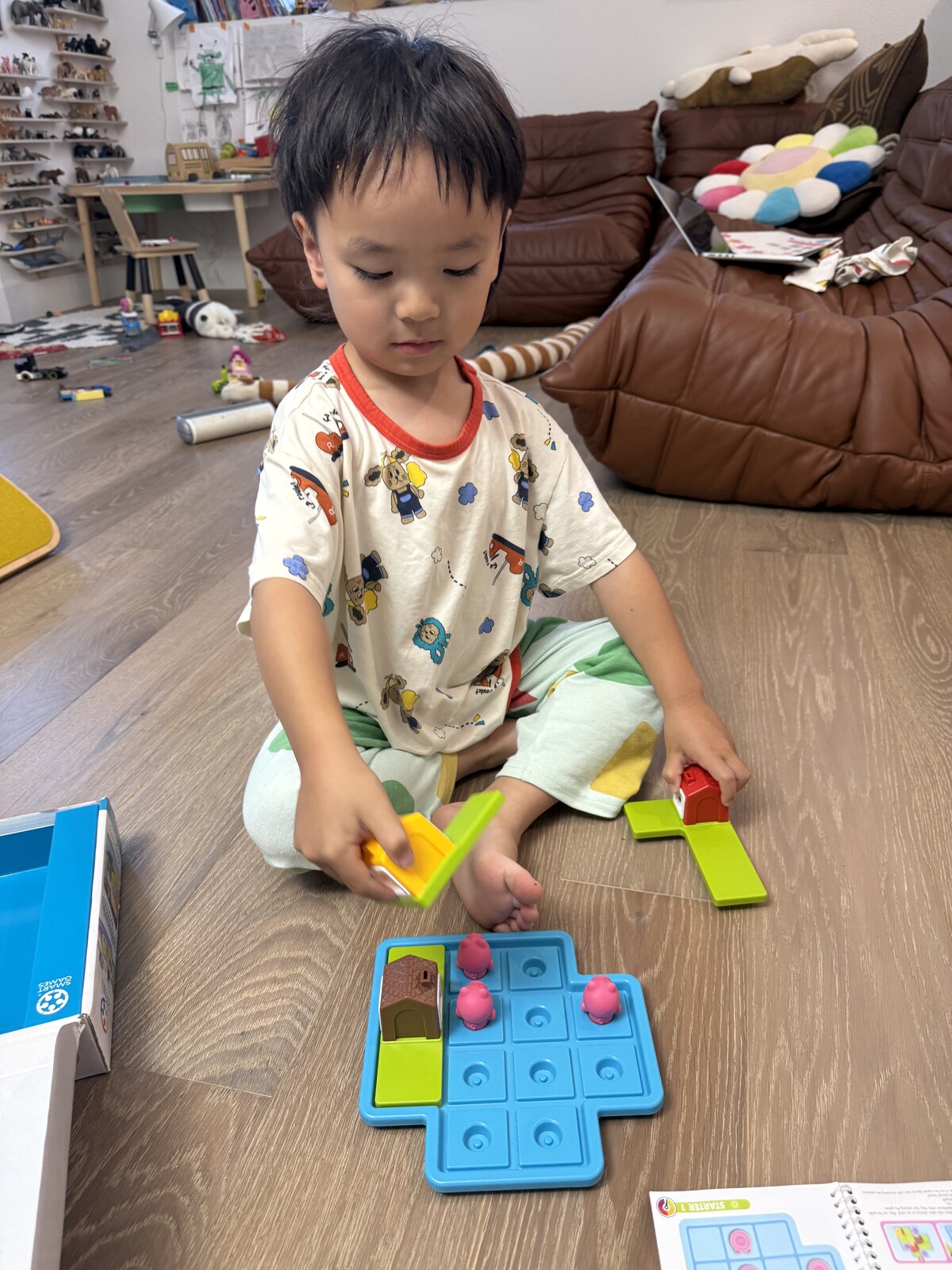 Jichang playing the Three Little Piggies puzzle game on the floor at home