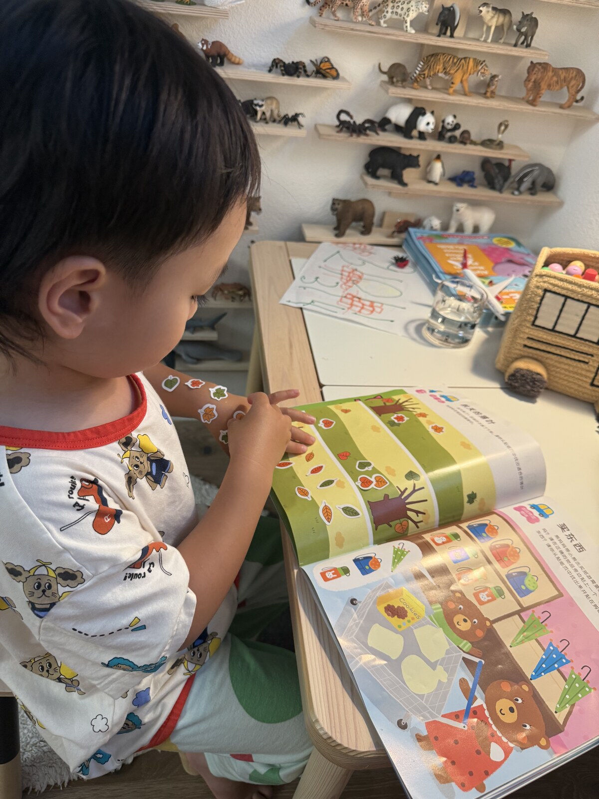 Jichang collecting stickers on his arm before pasting them into a sticker book