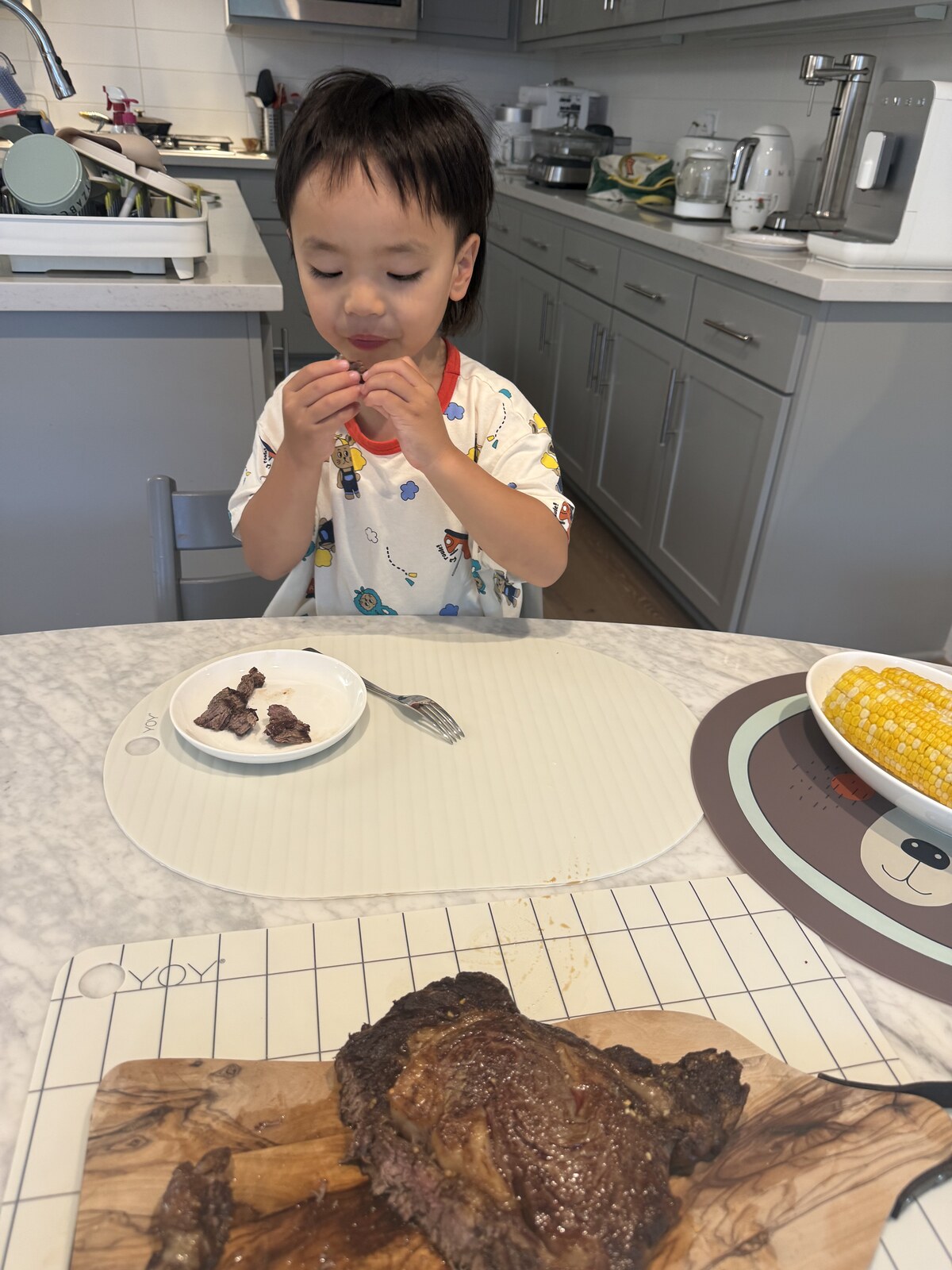 Jichang eating steak and corn at dinner