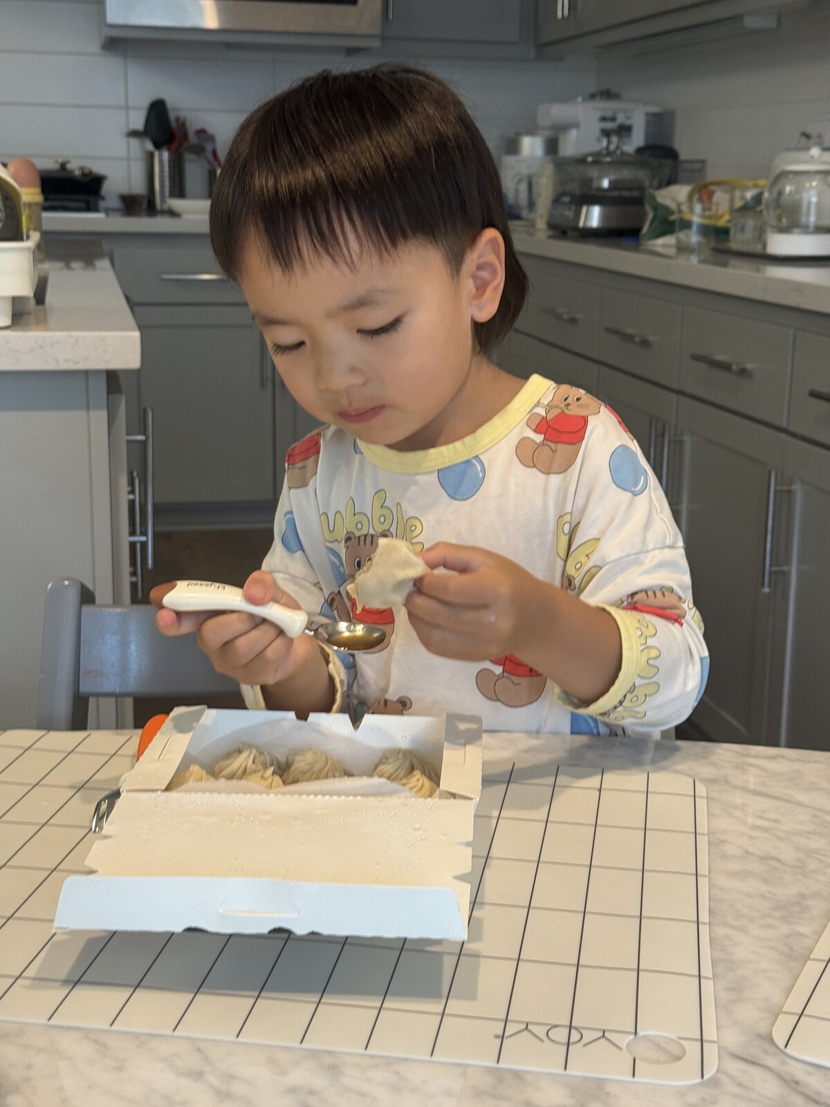 Jichang carefully putting Xiao Long Bao soup into a spoon before eating dinner