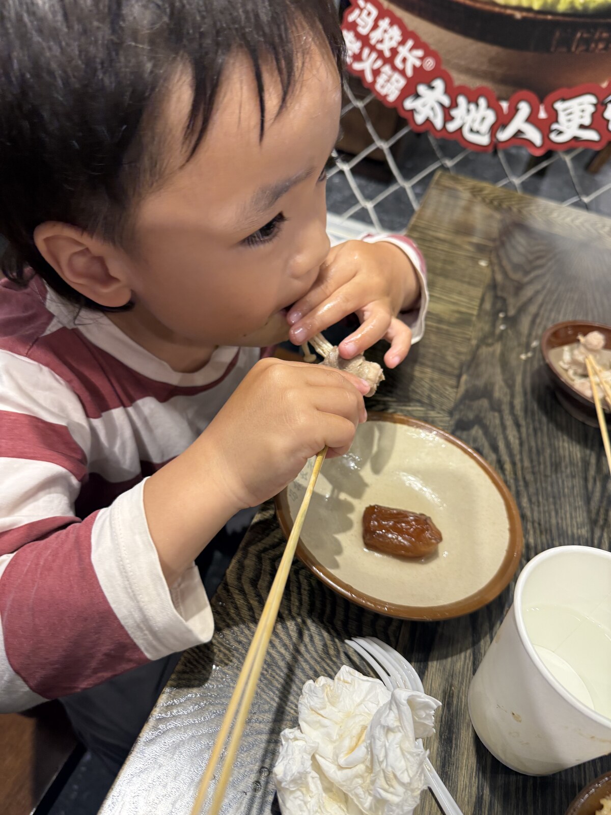 Jichang eating a skewer for the first time at dinner