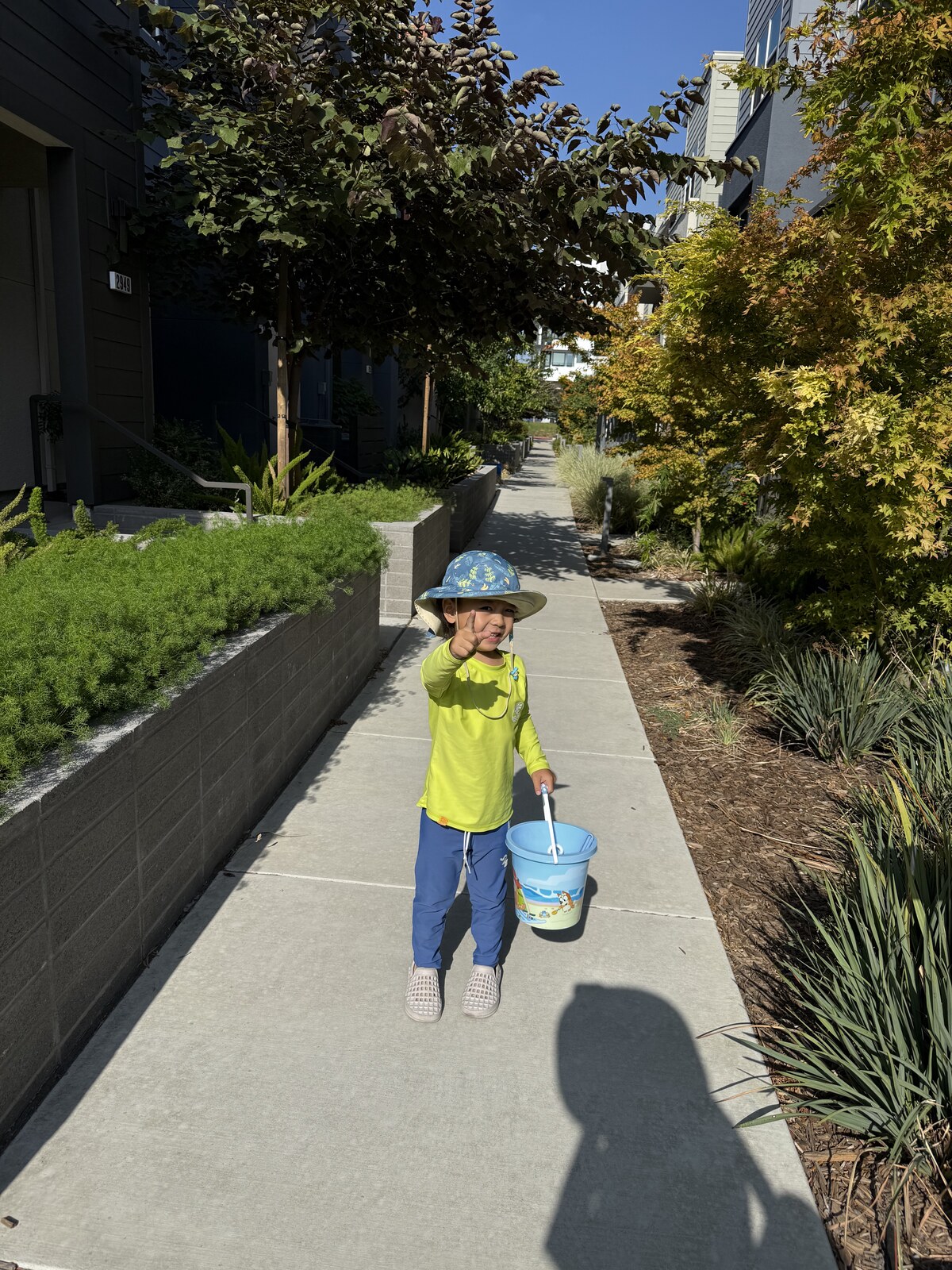 Jichang carrying a Bluey bucket while walking through the hallway to the car