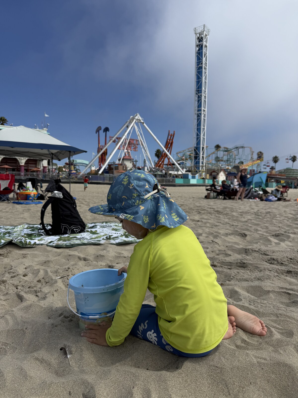 Jichang digging in the sand with his Bluey bucket at Santa Cruz Beach