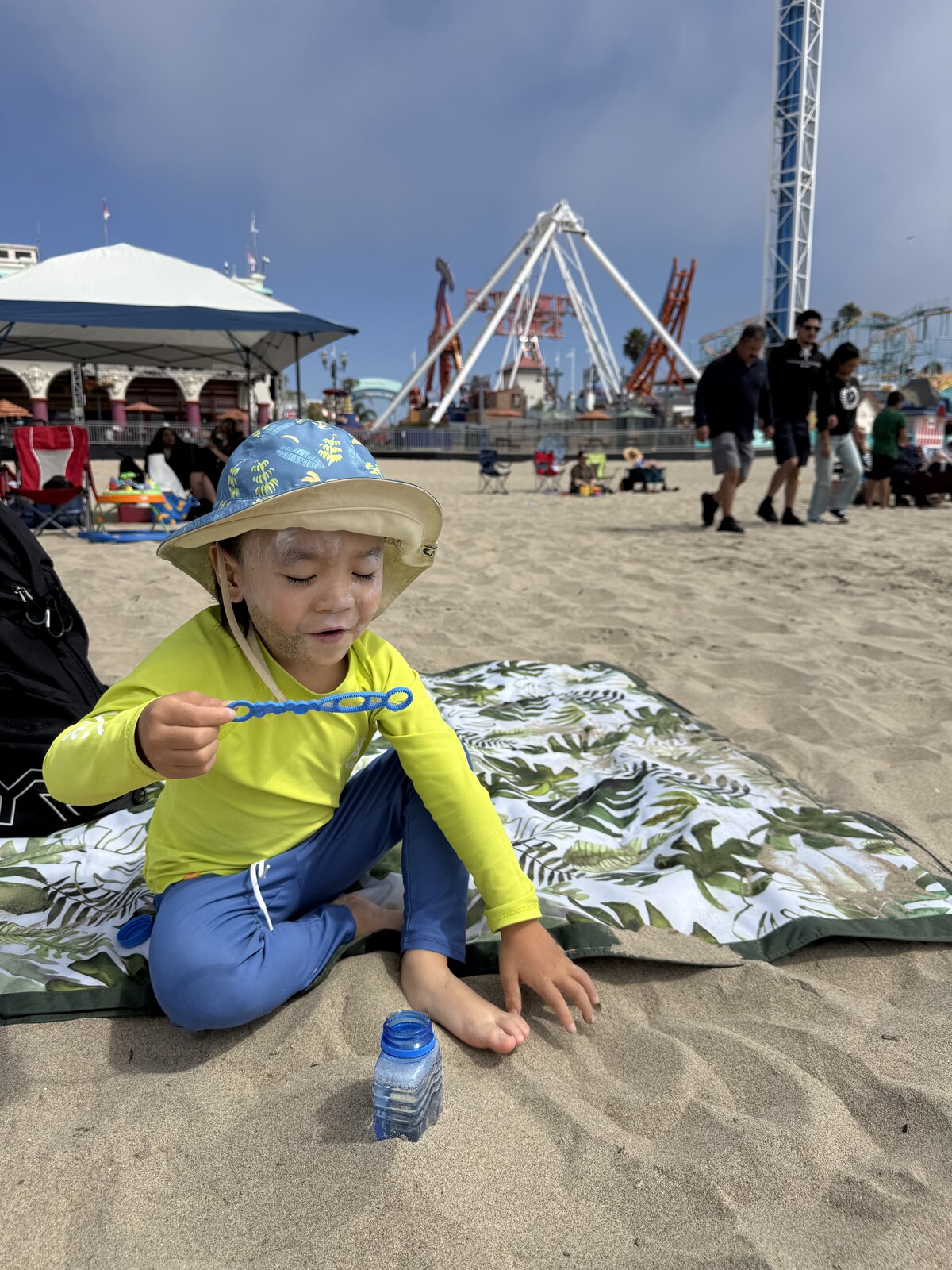 Jichang blowing bubbles while sitting on the beach