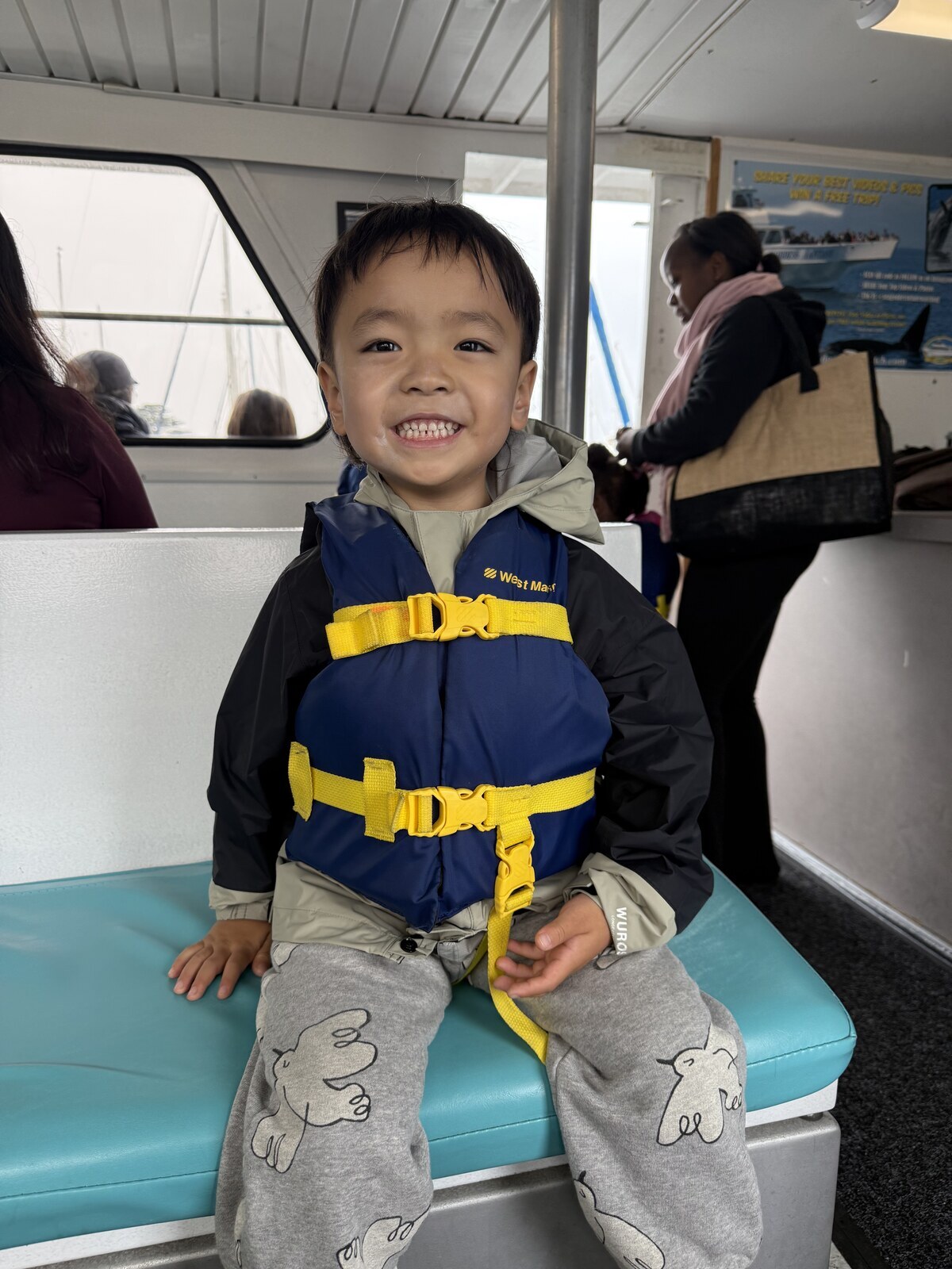Jichang sitting on the whale watching boat in a life jacket